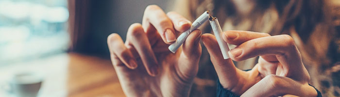 closeup image of female breaking a cigarette