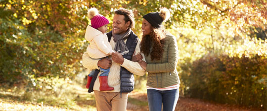 family walking outside during autumn with young daughter