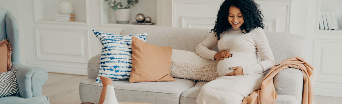 pregnant woman sitting on living room couch